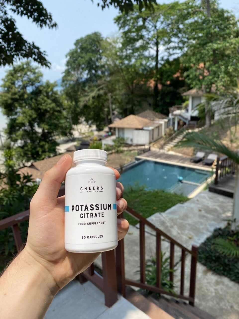Cheers Potassium Citrate w dłoni na tle ogrodu